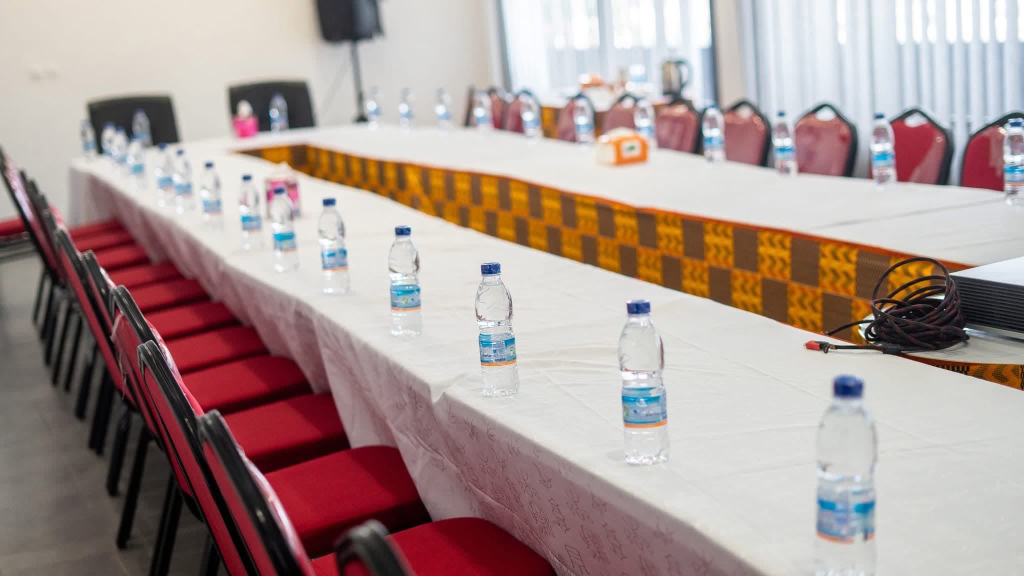 Salle de conférence avec tables en U et chaises rouges